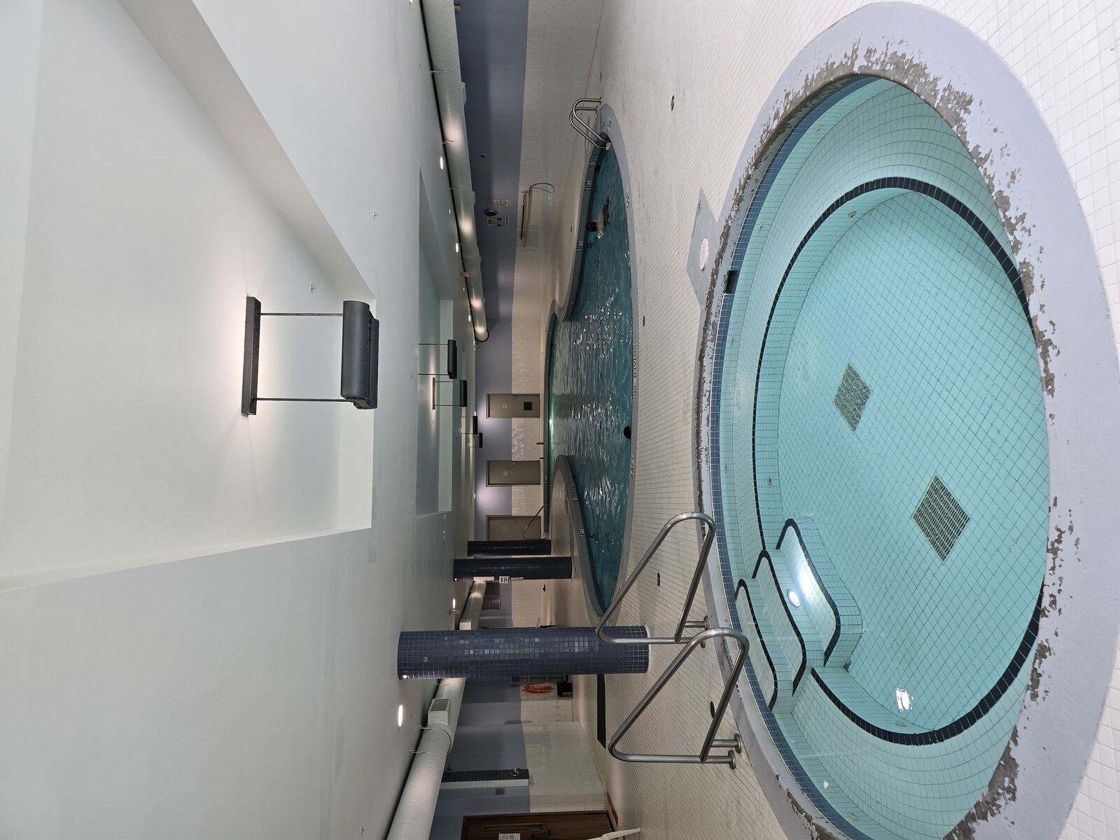 Indoor hot tub with pool in background