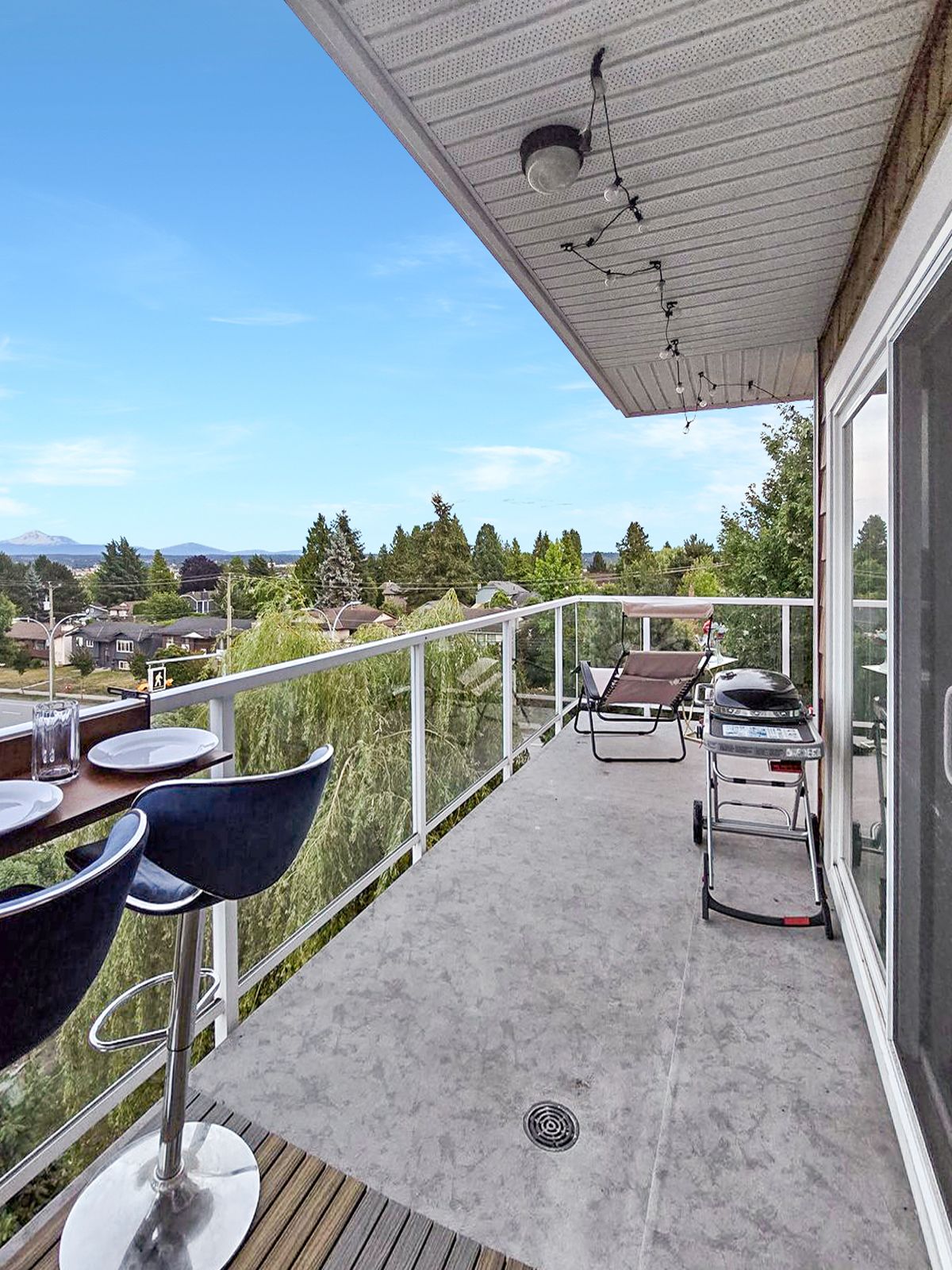 Reverse angle of the wraparound balcony, looking from the lounge area back toward the bar table