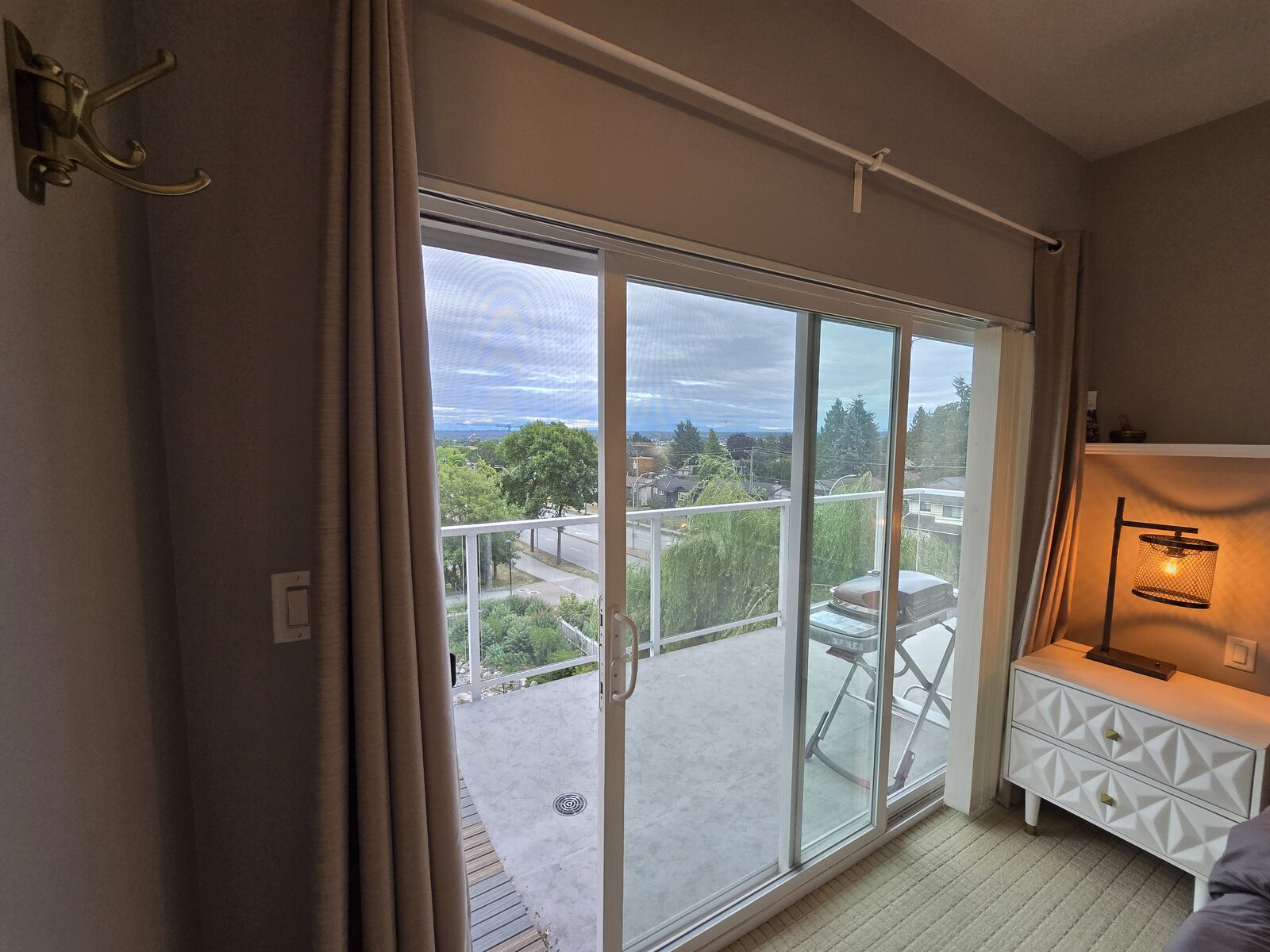 Balcony sliding door and reading lamp seen from the bedroom
