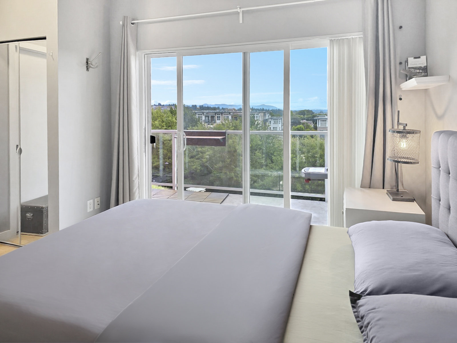 View from the bed looking toward the private balcony and mountain skyline