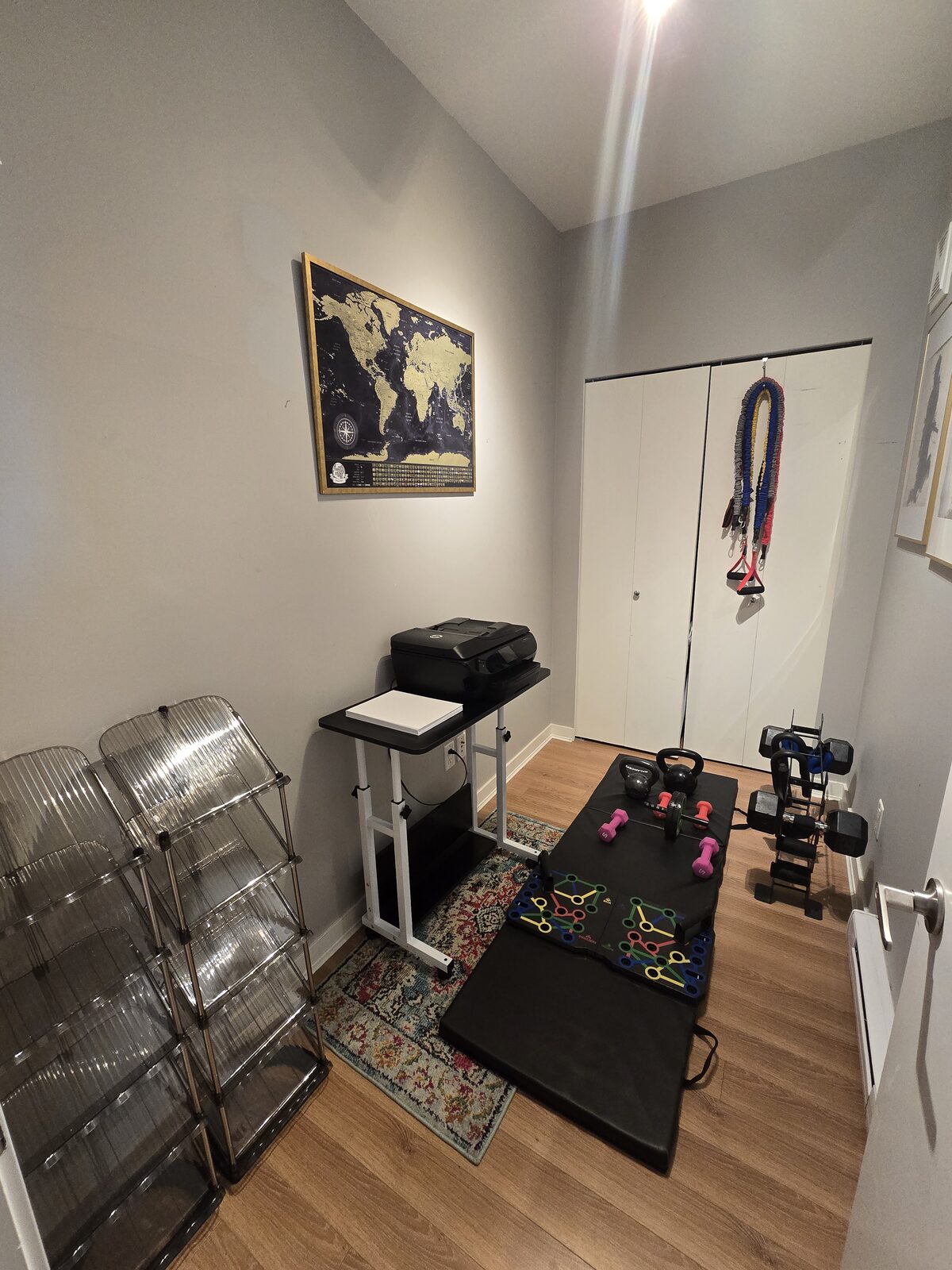 Private fitness room with exercise mat, dumbbells, kettlebells and closet storage