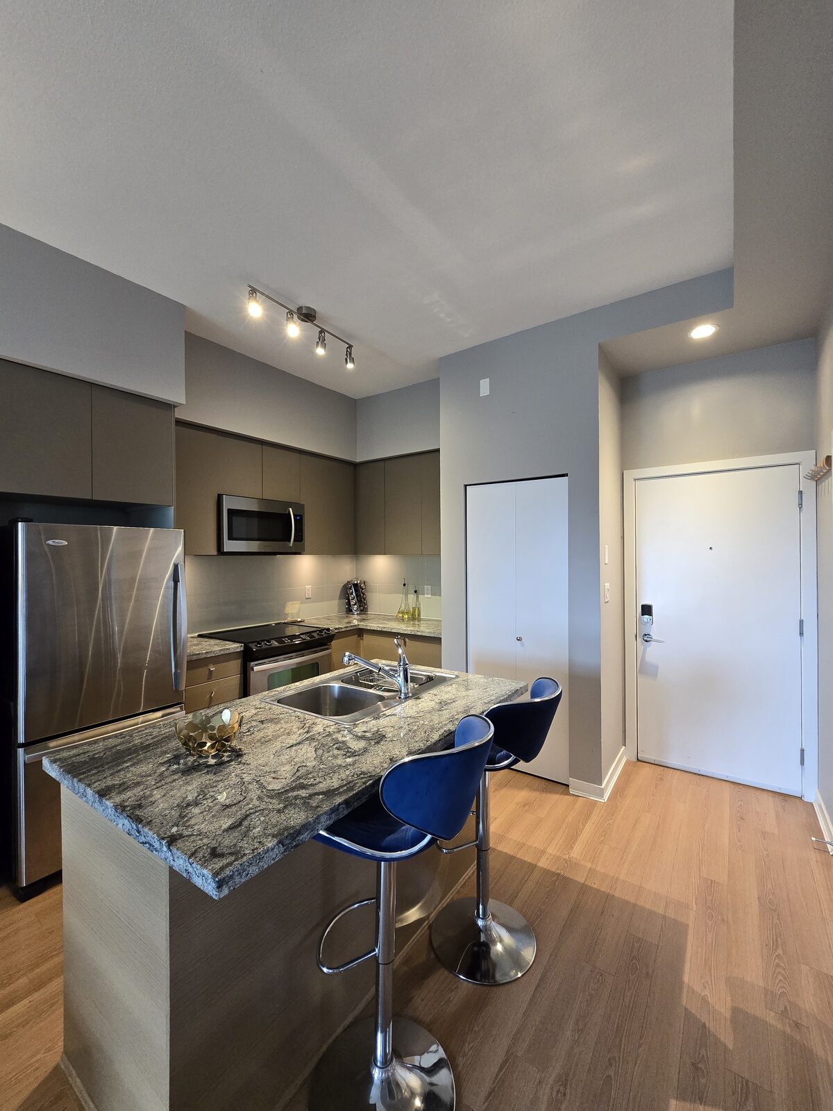 Full kitchen with stainless steel appliances, granite island, and breakfast bar seating for two