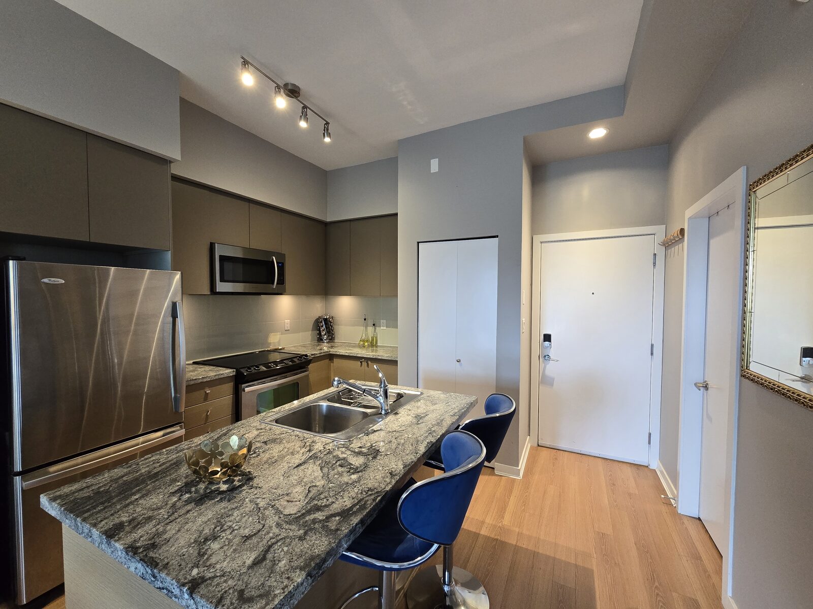 Kitchen view showing the island, hallway, and entrance to the den