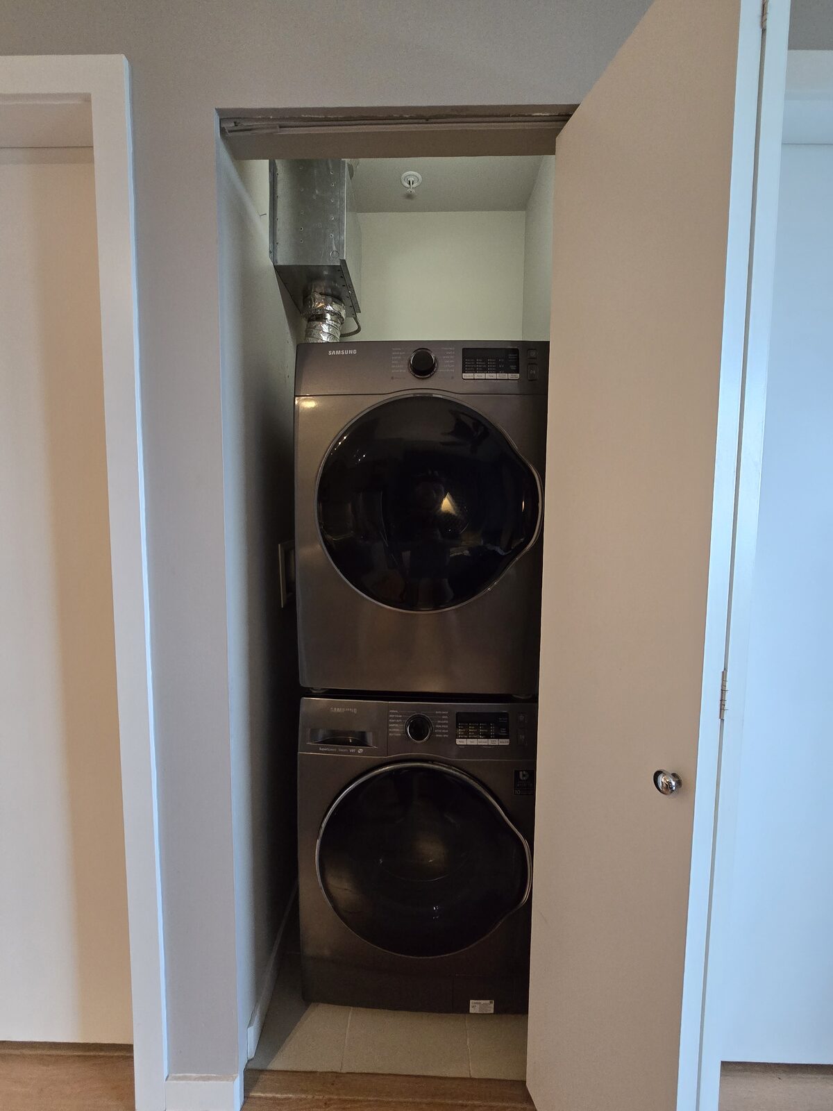 In-suite laundry closet with folding door, tucked off the hallway